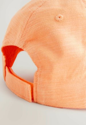 Orange baseball cap med tekstureret stof, der har en buet skygge, justerbar rem og syninger nær bunden.