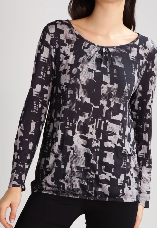 Svart och grå långärmad topp med abstrakt mönster, rund halsringning och rynkad detalj vid bröstet; mjukt, lätt material.