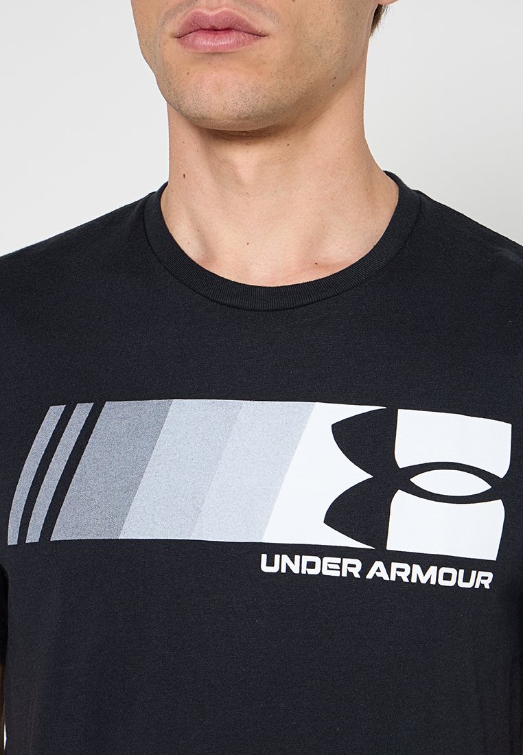 Schwarzes T-Shirt aus Baumwolle, mit einem Verlaufdesign in Grautönen und einem weißen "Under Armour"-Logo über der Brust.