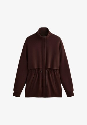 Giacca cappuccio marrone con chiusura con zip, cordoncino elastico in vita e due tasche frontali. Realizzata in tessuto morbido e textured.