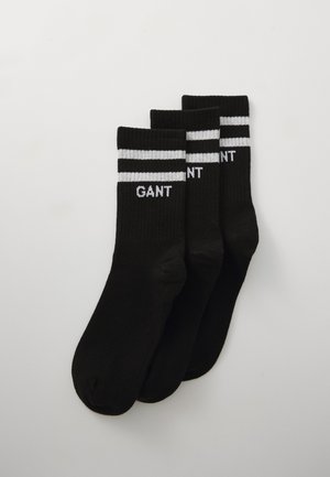 Schwarze Socken mit zwei weißen Streifen oben und dem weißen Text "GANT". Ripptextur, standardmäßiges sportliches Design. Set mit drei Paaren.