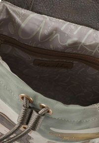 Weiches mintgrünes Lederinnere einer Tasche mit grauem Stofffutter, ausgestattet mit einer Reißverschlusstasche und dekorativer Messingbeschläge.