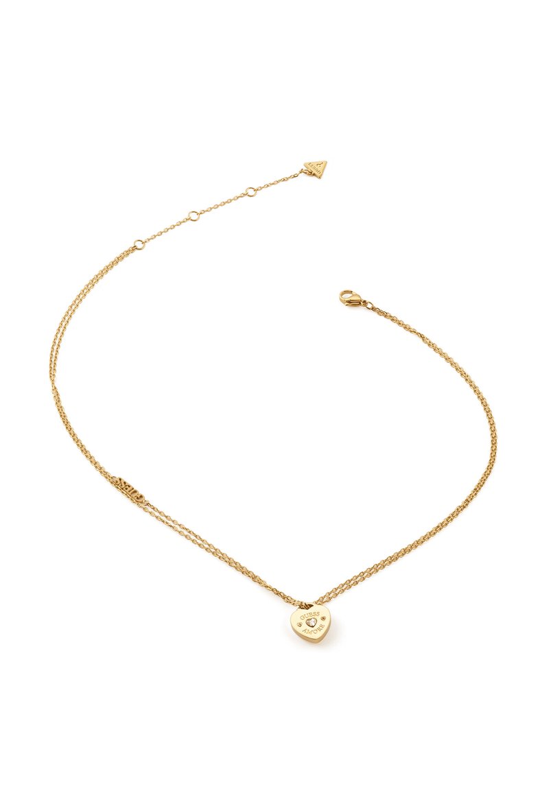 Collana in oro con un pendente a forma di cuore, caratterizzato da testo inciso e piccoli accenti, che mostra un design stratificato e una texture liscia.