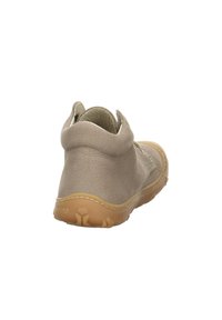 Botas de tobillo beige hechas de lona con cuello acolchado, punta redonda y suela de goma. El diseño presenta costuras mínimas y una textura suave.
