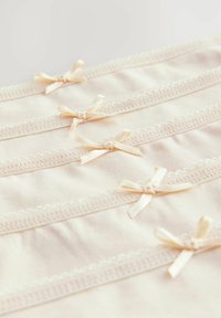 Šviesiai smėlio spalvos audinys su subtiliu nėrinių apvadu ir mažais satino kaspinėliais, tolygiai išdėstytais paviršiuje, su lygiu ir minkštu tekstūra.