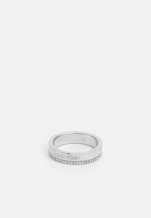 Silver Calvin Klein ring with engraved logo and a row of small clear crystals around the band, size 52.