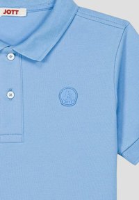 Lichtblauw poloshirt gemaakt van gestructureerde stof met een drieknopensluiting. Voorzien van een geborduurd logo in het midden aan de linkerborstzijde.
