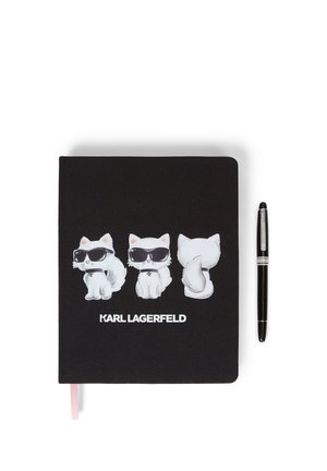 Carnet noir avec trois chats blancs portant des lunettes de soleil imprimés sur la couverture et un stylo noir placé à côté.
