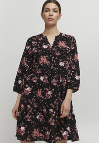 Abito nero a fiori con motivi di fiori rosa e bianchi, chiusura a bottoni, maniche 3/4 e design a gonna svasata.