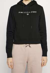 Schwarze, verkürzte Kapuzenjacke aus weichem Material mit einem Logo-Print auf der Vorderseite. Sie hat eine verstellbare Kordelzugkapuze und gerippte Bündchen.