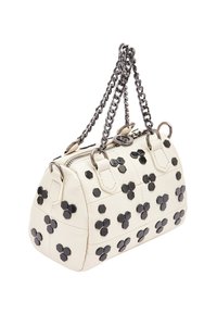 Witte leren handtas met zwarte hexagonale studs, ritsluiting en dubbele kettingbanden. Afgeronde vorm, gestructureerd oppervlak.