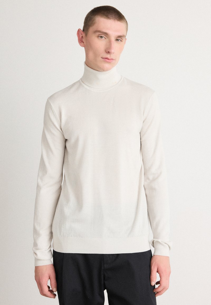 Helebeež turtleneck-sviiter, mis on valmistatud siledast kudumisest, millel on pika varrukaga ja slim-fit disain, millel on soonikkoes mansetid ja hem.