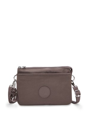 Brown, rectangular crossbody bag made of fabric, featuring a zip closure, an outer pocket, and a logo patch. Adjustable strap included.