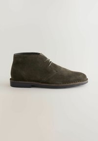 Dark olive green suede desert boot with two eyelets and black sole, shown from the outer side on a neutral background.