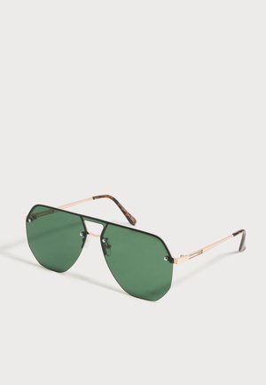 Sonnenbrille mit großen, eckigen grünen Gläsern, dünnem goldfarbenem Metallrahmen und Bügelenden mit Schildpattmuster auf weißem Hintergrund.