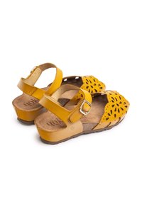 Yellow leather sandals with an open toe, floral cut-out design, adjustable ankle strap, and a contoured cork footbed.