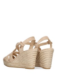 Sandalias de cuña beige con plataforma de yute trenzado y correas de tela suave. Presenta una correa para el tobillo ajustable y un acento metálico.