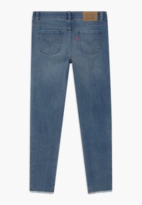 Jeans de mezclilla azul oscuro con corte recto, un ligero desgastado y un diseño clásico de bolsillo trasero con detalles de costura.
