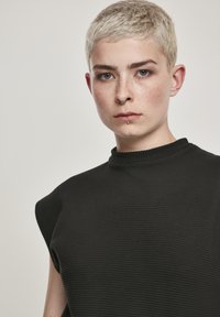 Zwarte geribbelde mouwloze top met hoge hals, gestructureerde schouders en een textiele stof, die een moderne en minimalistische uitstraling biedt.