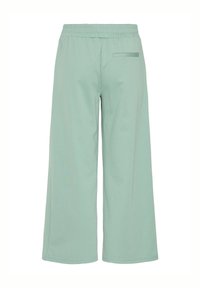 Lichtgroene, wijde broek met een elastische tailleband en een enkele achterzak. Gemaakt van zachte stof met een gladde textuur.