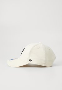 Beige színű pamut baseball sapka ívelt napellenzővel, a fronton fekete logóval és az oldalon egy kis hímezett "47"-tel.