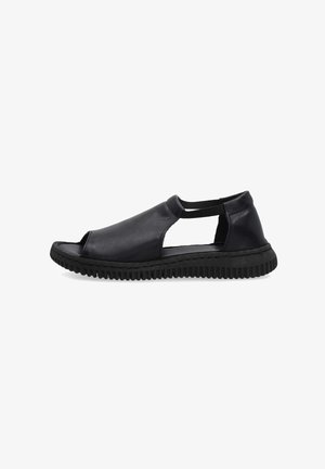 Zwarte leren open-toe sandaal met elastische zijbandjes en dikke gestructureerde zool, ontworpen voor casual of dagelijks gebruik.