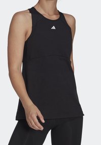 Débardeur de sport noir avec une coupe ajustée, sans manches et un col arrondi. Présente un petit logo blanc sur la poitrine.