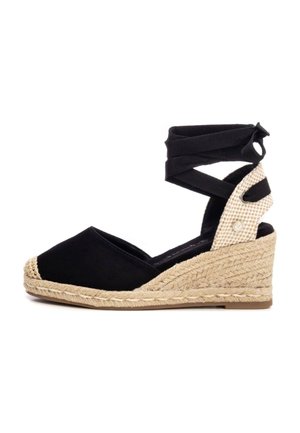 Zapato cuña espadrille negro con puntera redonda, suela de yute trenzado y tiras de tela cruzadas en el tobillo. Acento texturizado en el talón.