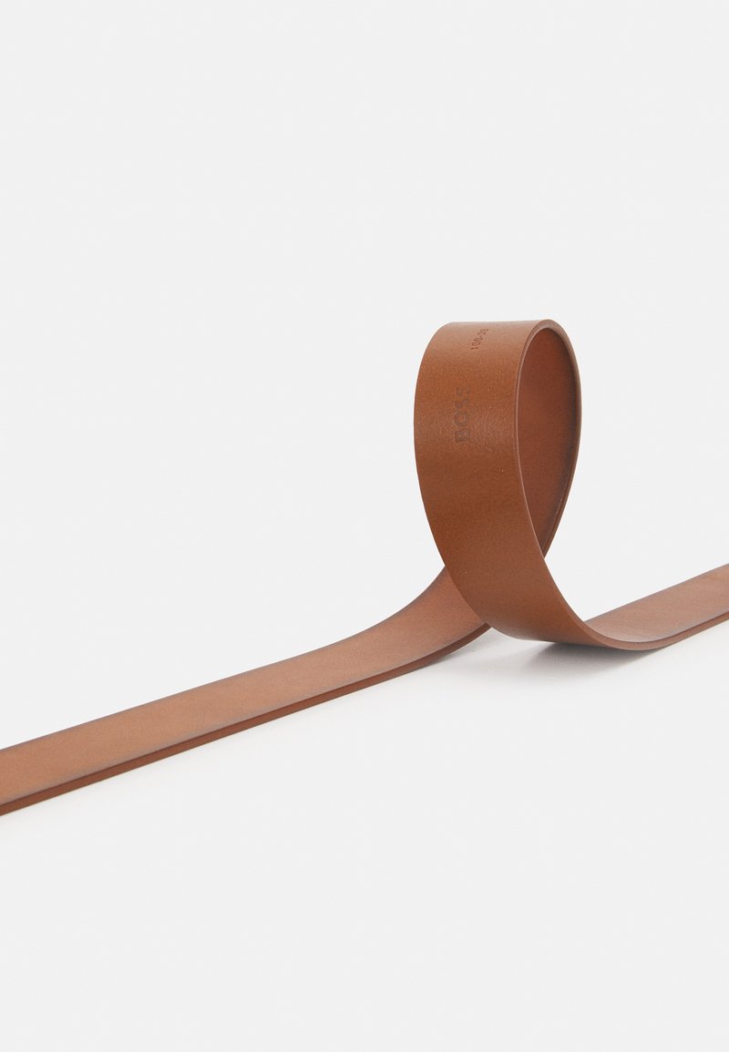 Brauner Lederband, flach und glatt, mit einem leichten Glanz. Einfaches, durchgehendes Schleifendesign mit dezentem Branding, das auf der Oberfläche sichtbar ist.