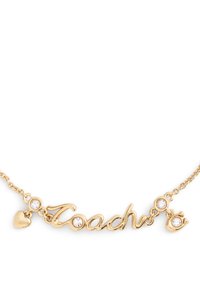 Collier en or avec le mot "Coach" écrit en cursive, orné de deux strass clairs et d'un petit pendentif en forme de cœur. Le design de la chaîne est délicat.
