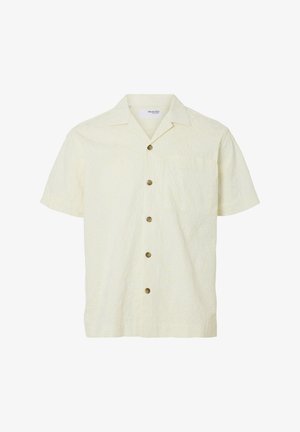 Kratke rokave, svetlo rumena srajca z teksturiranim cvetličnim vzorcem, petimi rjavimi gumbi, ovratnikom in enim žepom na prsih.