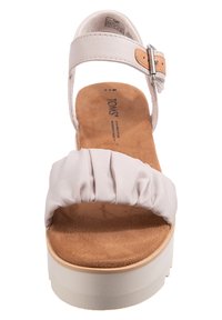 Lichtroze platform sandaal met een zachte, gerimpelde stoffen bovenkant, verstelbare band en een gestructureerde bruine voetbed op een witte rubberen zool.