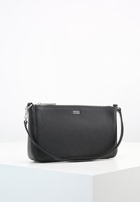 Sorte læder clutch taske med en struktureret overflade, lynlåslukning og aftagelig skulderrem. Har en logo-plade på forsiden.