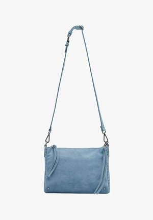 Sac bandoulière en daim bleu clair avec bandoulière réglable, fermeture éclair et pompons décoratifs sur fond blanc.