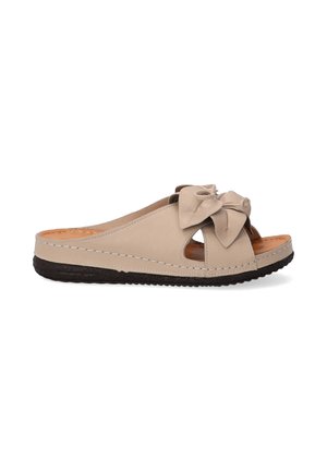 Beige leather slide sandal featuring a bow accent, open toe design, and contrasting dark rubber sole with stitched detailing.