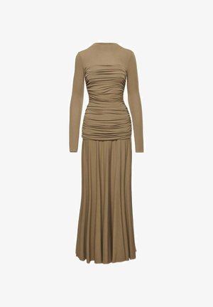 Dlouhé, přiléhavé šaty v měkké hnědé tkanině. Mají dlouhé rukávy, nařasený přední díl a splývavou plisovanou sukni. Hladká textura po celém povrchu.