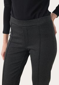 Kalhoty s šedým houndstooth vzorem a vysokým pasem, s plochým předním dílem, bočními kapsami a štíhlým střihem.
