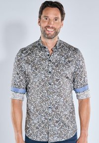 Kurzarmhemd mit braunem und blauem Paisleymuster aus Baumwolle. Knopfverschluss vorne mit umgeschlagenen Ärmeln und kontrastierenden blauen Akzenten.