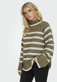 Raitoja ruskea ja valkoinen neulepaita, jossa on korkea kaulus, ribbitettu pinta, sivuhalkiot ja leveät hihat, valmistettu pehmeästä villamaisesta materiaalista.