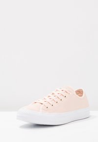 Hellblaue Leinen-Sneaker mit weißer Gummisohle, runder Zehenpartie und mehreren Ösen. Das strukturierte Material und die flachen Schnürsenkel verbessern das Design.