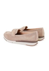 Beige geperforeerde leren schoenen met een vlakke zool en een strikaccent aan de voorkant, met een ronde neus en een contrasterende witte tussenzool.