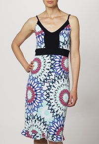 Hihaton, tiukasti istuva mekko, jossa on musta yläosa ja värikäs kukkakuosi sinisen, pinkin ja vihreän sävyissä. Mekon alaosa on poimutettu.