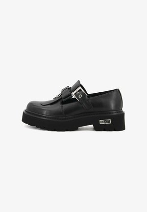 Scarpe in pelle nera con punta tondeggiante, cinturino regolabile con fibbia, suola in gomma spessa e superficie testurizzata. Presenta un accento di hardware in argento.