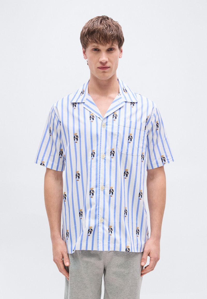 Κοντομάνικο πουκάμισο με κουμπιά,  σε λευκές και γαλάζιες ρίγες με μικρά σχέδια καρτούν, φτιαγμένο από ελαφρύ ύφασμα.