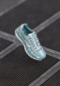Nike tenisice s mrežastom gornjim dijelom u smeširu zelenu i bijelu boju, uzorkovanim prekrivačima, podstavljenim potplatom i kontrastnim vezicama.