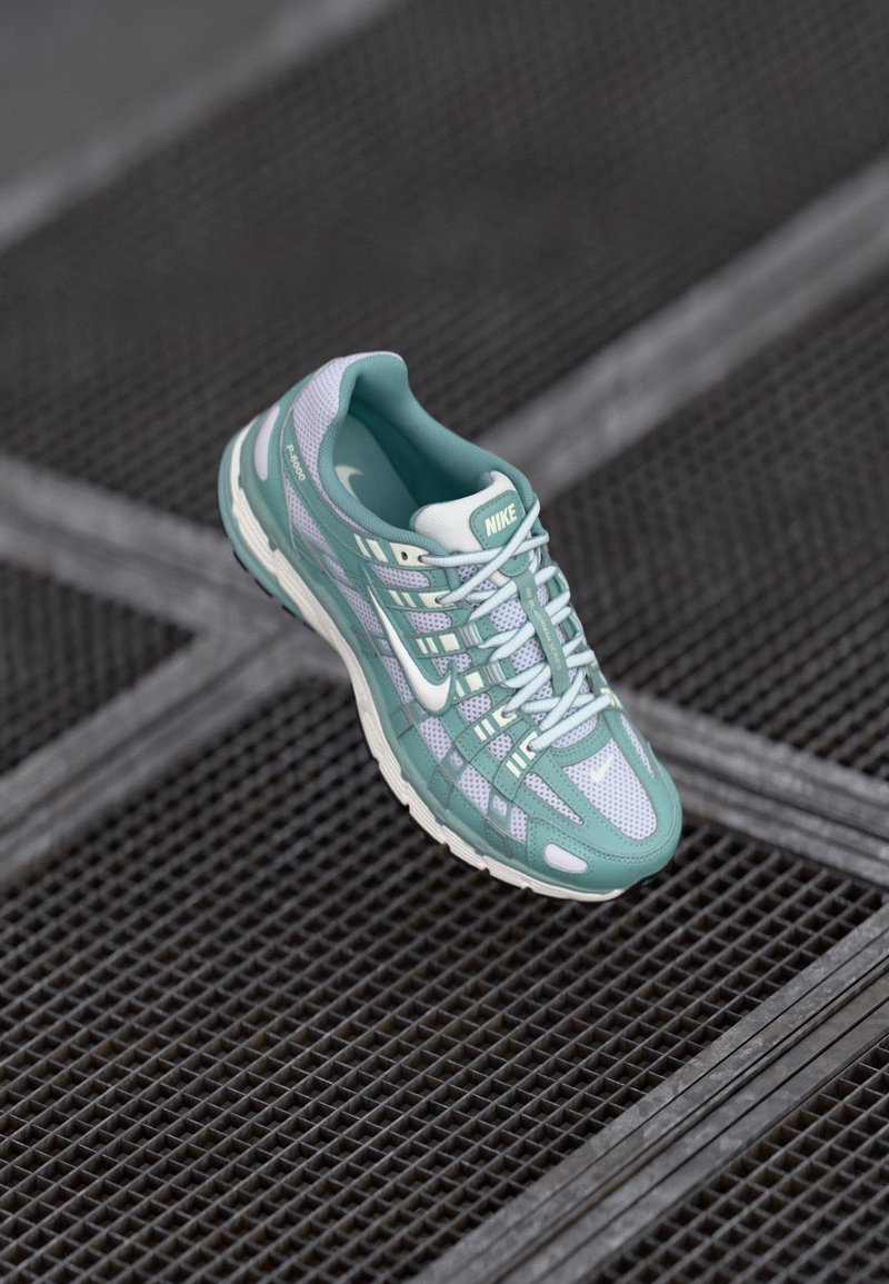 Nike tenisice s mrežastom gornjim dijelom u smeširu zelenu i bijelu boju, uzorkovanim prekrivačima, podstavljenim potplatom i kontrastnim vezicama.
