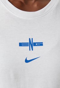 White cotton t-shirt featuring blue printed text "ENG" and a blue Nike logo. Round neckline and soft, smooth texture.