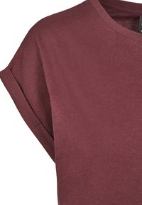 T-shirt bordeaux a maniche corte con scollatura rotonda e maniche arrotolate. Realizzato in morbido tessuto di cotone, presenta una texture liscia.