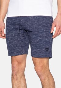 Shorts bleu marine en tissu texturé avec une taille à cordon et un petit logo brodé sur la jambe gauche.
