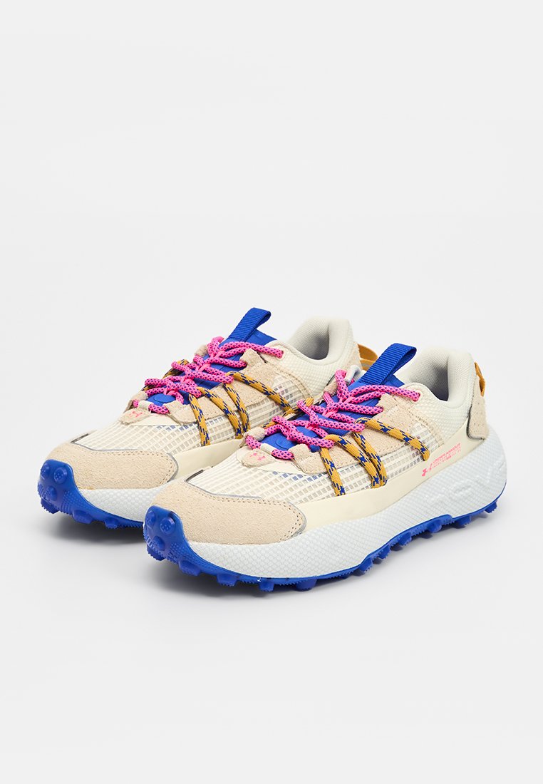 Zapatillas con una parte superior de malla beige, acentos en azul y naranja, cordones rosas y una suela texturizada blanca y azul. Presenta un patrón de tracción robusto.
